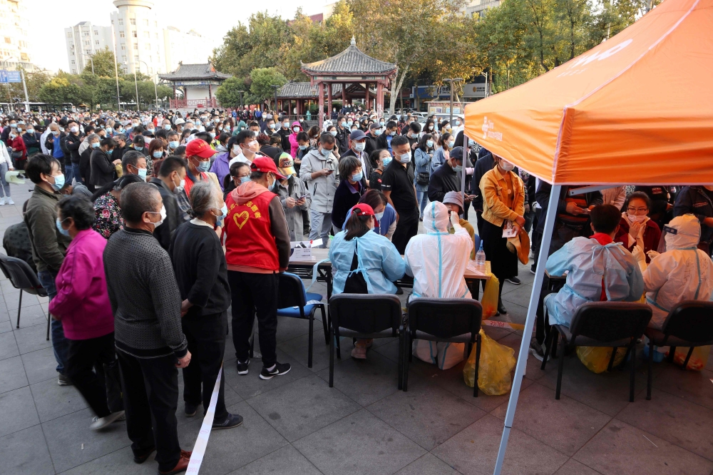 This photo taken on October 12, 2020 shows residents lining up to be tested for the COVID-19 coronavirus, as part of a mass testing program following a new coronavirus outbreak in Qingdao, in China's eastern Shandong province. China OUT / AFP / STR