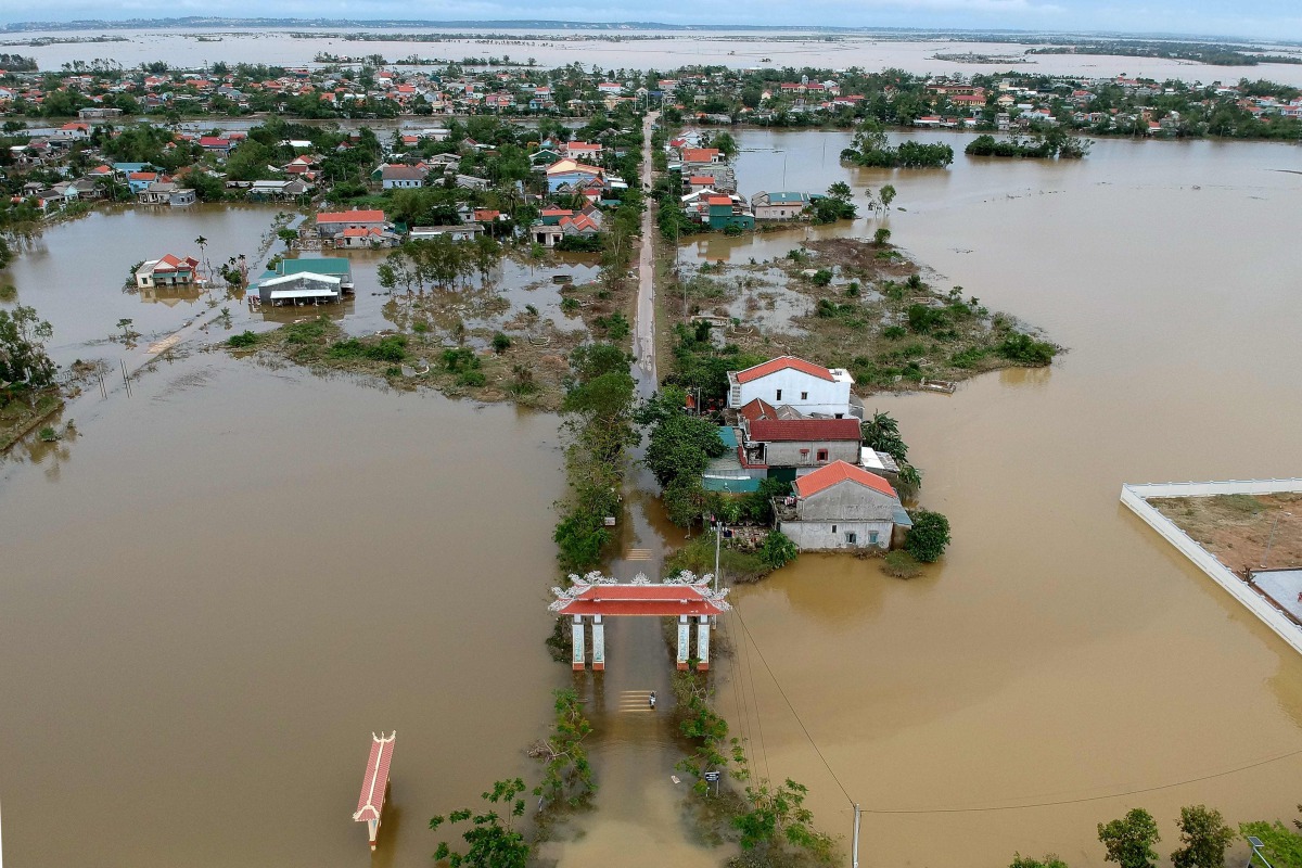 An aerial picture shows houses submerged in flood waters caused by heavy rains in Quang Dien district in central Vietnam's Hue province on October 15, 2020. / AFP / MANAN VATSYAYANA
