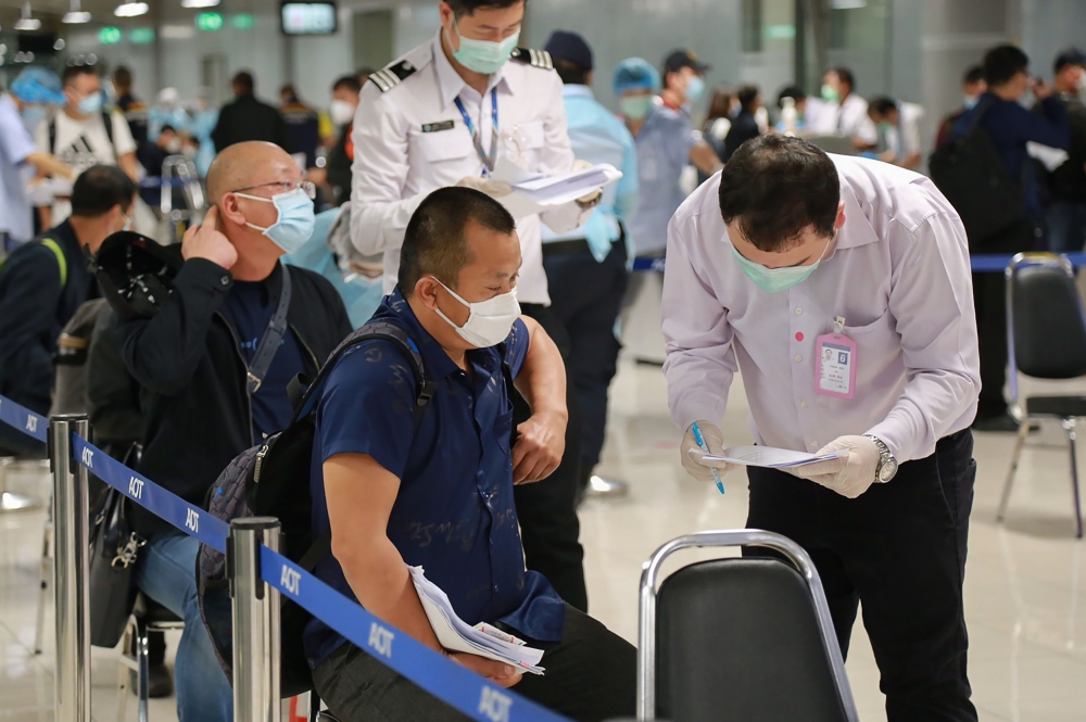 This handout photo taken on October 20, 2020 and released on October 21 by the Airports of Thailand company shows members of a group of 39 Chinese visitors with special tourist visas going through arrival measures to halt the spread of the COVID-19 corona