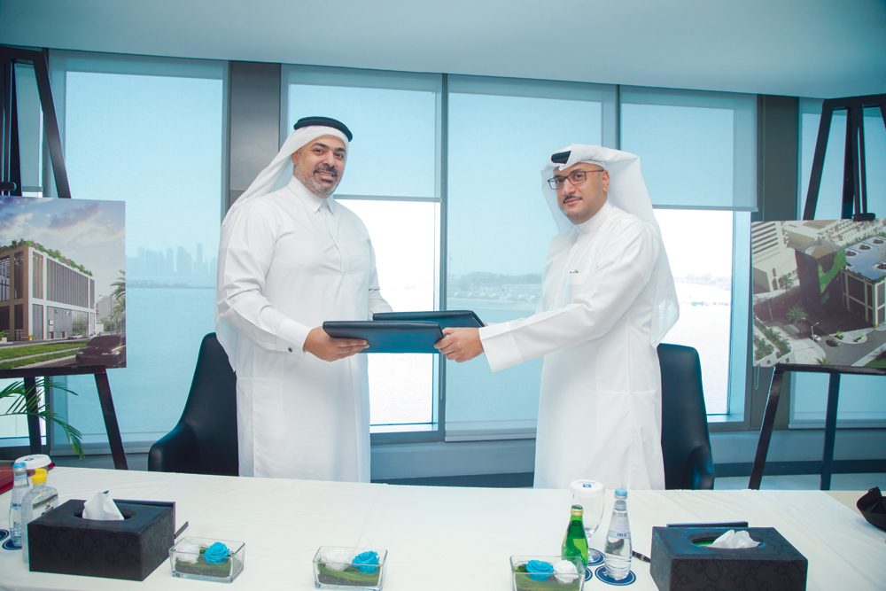 Qatar Cool CEO Yasser Al Jaidah (left) and Gulf Contracting Company’s Director Abdul Rahman Al Darwish exchanging documents after the contract signing ceremony yesterday.