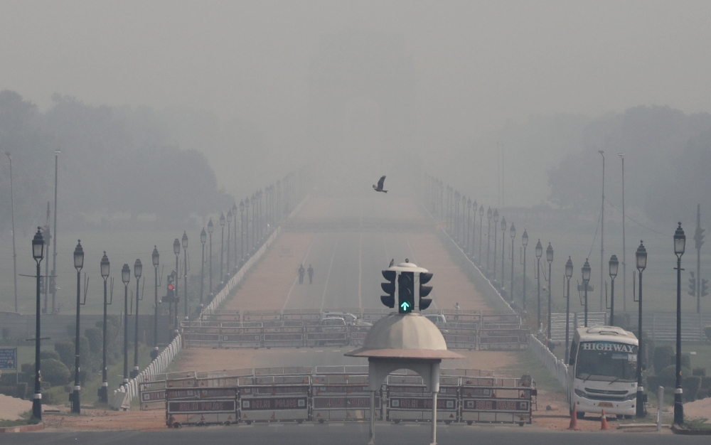 People walk near India Gate on a smoggy morning in New Delhi, India, October 22, 2020. REUTERS/Anushree Fadnavis/File Photo