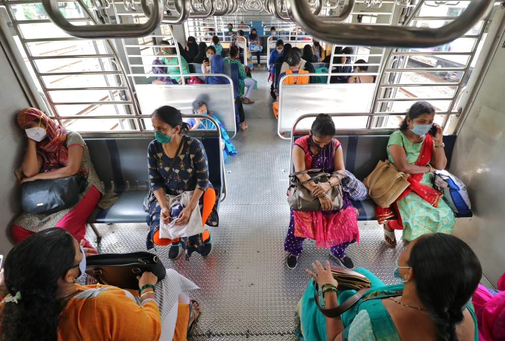 Women wearing protective face masks commute in a suburban train after authorities resumed the train services for women passengers during non-peak hours, amidst the coronavirus disease (COVID-19) outbreak, in Mumbai, India, October 21, 2020. REUTERS/Nihari