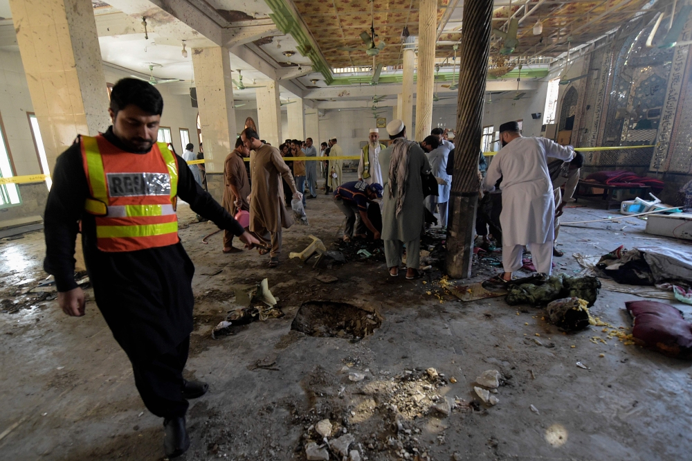 Rescue workers collect remains at the site of a blast in a religious school in Peshawar on October 27, 2020. AFP / Abdul Majeed 