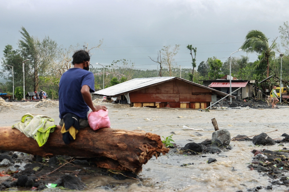 A man looks at his house buried under the pile of rubble and sand following flash floods brought by Typhoon 'Goni' in Barangay Busay, Daraga town, Albay province, Philippines, November 1, 2020. REUTERS/Nino N. Luces