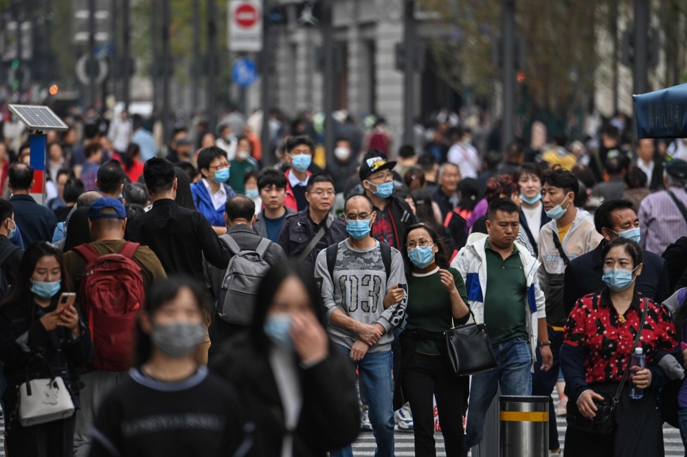 People walk along a pedestrian street in Shanghai on October 28, 2020. / AFP / Hector Retamal 