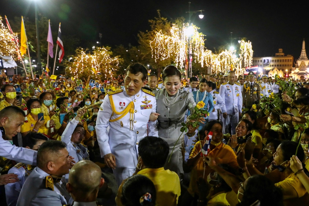 Thailand's King Maha Vajiralongkorn and Queen Suthida greet royalist supporters outside the Grand Palace in Bangkok on November 1, 2020 after presiding over a religious ceremony at a Buddhist temple inside the palace. / AFP / Jack TAYLOR