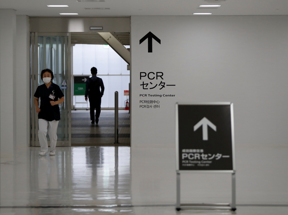 A medical worker walks at the entrance of the newly-opened Narita International Airport PCR Center operated by Nippon Medical School Foundation, a coronavirus disease (COVID-19) testing facility aimed at outbound travelers who need proof that they do not 