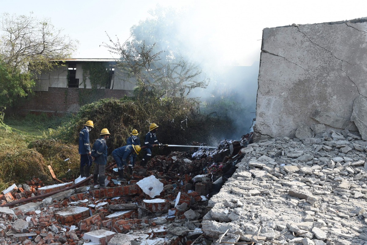Ahmedabad and Emergency Services personnel put out a fire after a fire collapsed a garment wharehouse, on the outskirts of Ahmedabad on November 4, 2020. At least 9 people have been reported dead, according to local media. / AFP / SAM PANTHAKY
