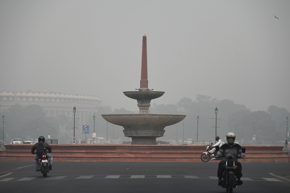 Commuters make their way along a road under heavy smog conditions near near the Indian parliament in New Delhi on November 9, 2020. / AFP / Sajjad HUSSAIN