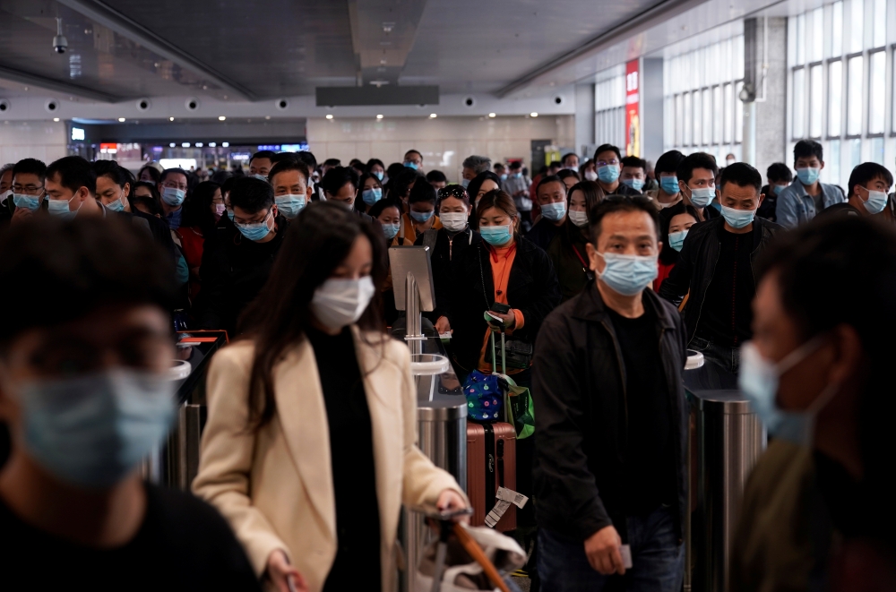 People wear face masks amid the global outbreak of the coronavirus disease (COVID-19) at Shanghai Railway Station in Shanghai, China, November 10, 2020. REUTERS/Aly Song
