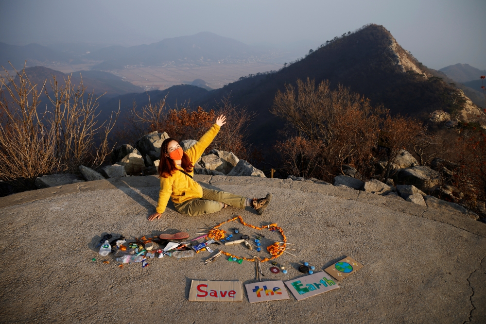 Kim Kang-Eun, an artist who leads Clean Hikers, poses artwork made from litter collected by members of Clean Hikers during their hikes, on the peak of a mountain in Incheon, South Korea, November 16, 2020. Reuters/Kim Hong-Ji