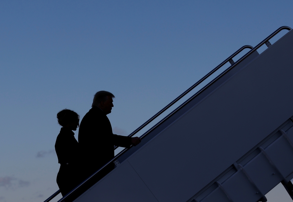 U.S. President Donald Trump departs next to first lady Melania Trump from the Joint Base Andrews, Maryland, U.S., January 20, 2021. REUTERS/Carlos Barria