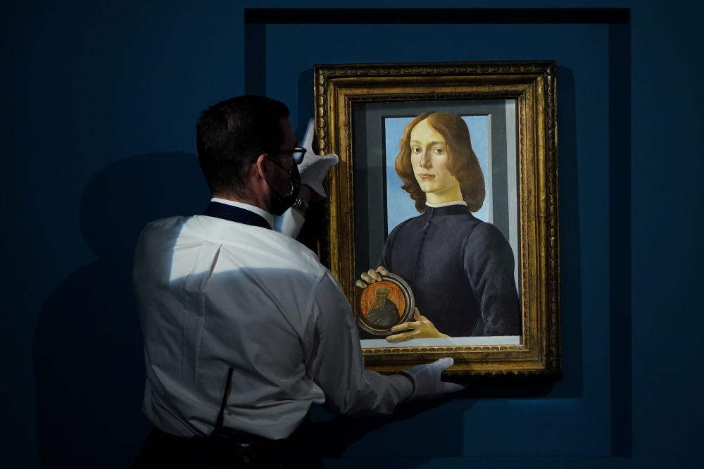 A worker at Sotheby's auctions takes Sandro Botticelli's 