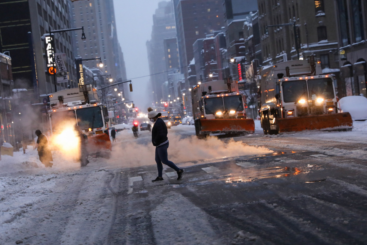 Snow plows wait at a traffic light on 8th Avenue during a snow storm, during the coronavirus disease (COVID-19) pandemic in the Manhattan borough of New York City, New York, U.S., February 1, 2021. REUTERS/Caitlin Ochs
