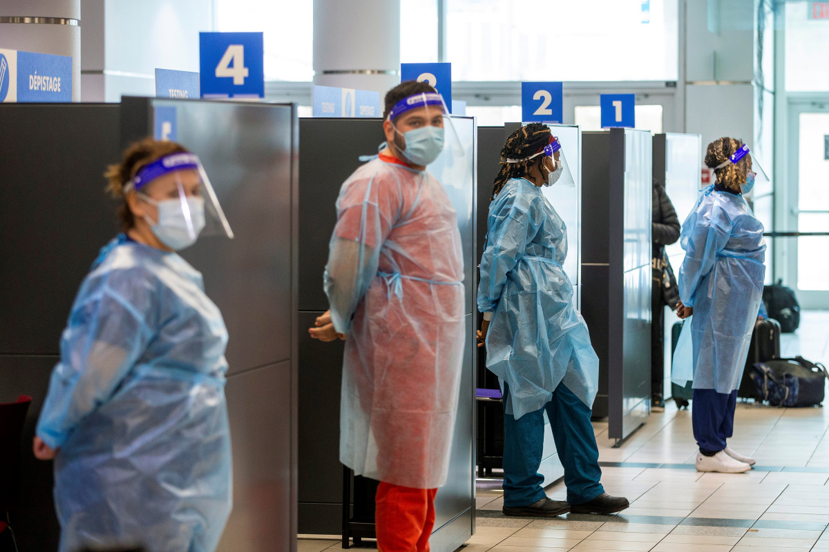 Healthcare workers prepare to test passengers as they arrive at Toronto's Pearson airport after mandatory coronavirus disease (COVID-19) testing took effect for international arrivals in Mississauga, Ontario, Canada February 1, 2021. REUTERS/Carlos Osorio