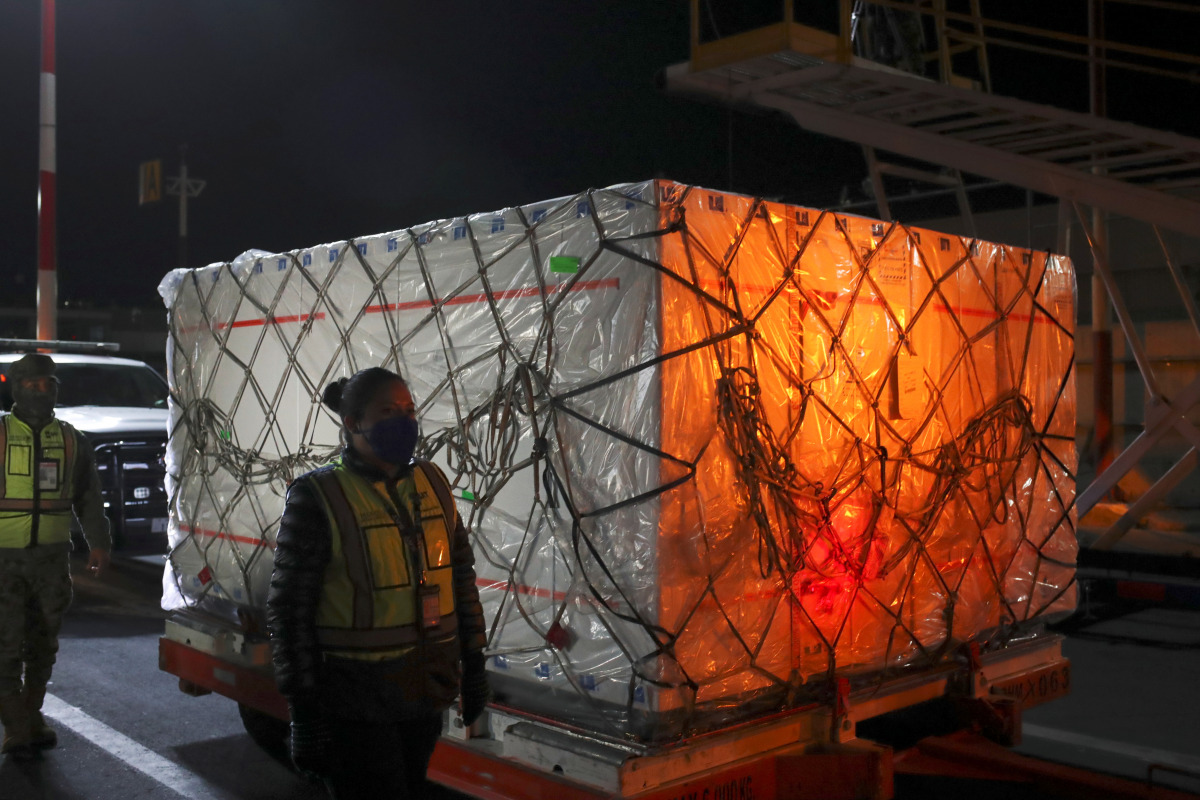 A security guard stands next to a batch of the AstraZeneca coronavirus disease (COVID-19) vaccine after its arrival at Benito Juarez's international airport in Mexico City, Mexico February 14, 2021. REUTERS/Henry Romero
