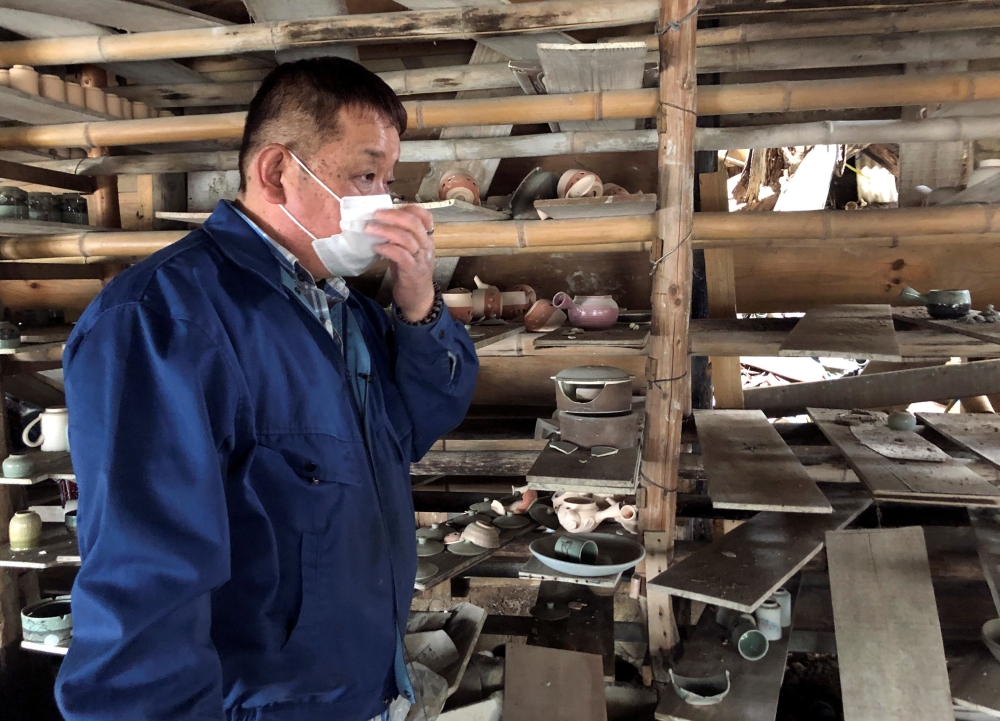 Toshiharu Onoda, 59, of the 13th generation to take on the family pottery business, looks at his studio damaged by the March 11, 2011 earthquake and tsunami, in Namie town, near the tsunami-crippled Fukushima Daiichi nuclear power plant, Fukushima Prefect