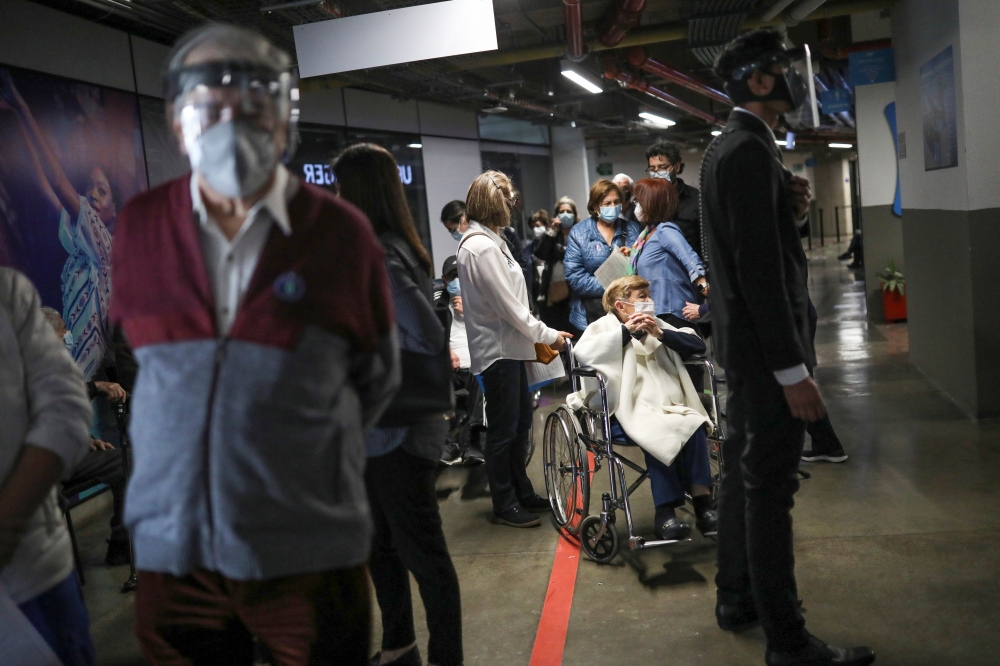 Elderly citzens wait in line to receive the Sinovac's CoronaVac coronavirus disease (COVID-19) vaccine during the mass vaccination program for the elderly people at Movistar Arena in Bogota, Colombia March 9, 2021. Picture taken March 9, 2021. REUTERS/Lui