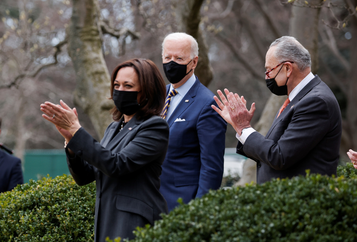 U.S. President Joe Biden is applauded by Vice President Kamala Harris and Senate Majority Leader Chuck Schumer (D-NY) as he arrives to speak about the $1.9 trillion 
