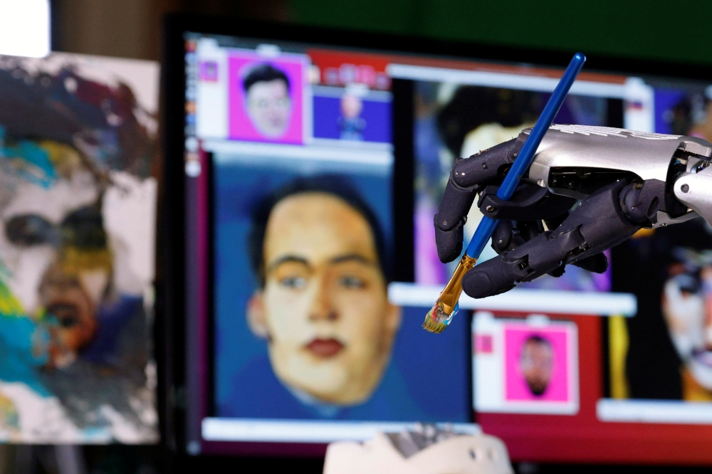 Humanoid robot Sophia, developed by Hanson Robotics, holds a brush during a demonstration before her non-fungible token (NFT) artwork is auctioned, in Hong Kong, China March 16, 2021. Picture taken March 16, 2021. REUTERS/Tyrone Siu