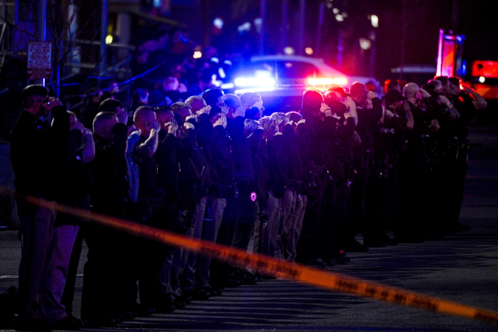 Law enforcement officers salute as emergency vehicles escort the body of slain police officer Eric Talley from the scene of a shooting at a King Soopers grocery store in Boulder, Colorado, U.S. March 22. 2021. Picture taken March 22, 2021. Michael Ciaglo/