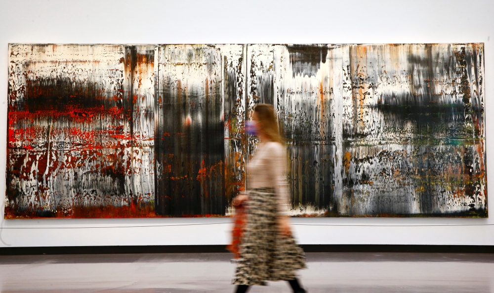 A woman walks past the painting 