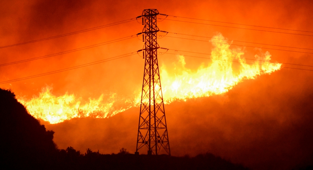 A wind-driven wildfire burns near power line tower in Sylmar, California, U.S., October 10, 2019. REUTERS/Gene Blevins/File Photo