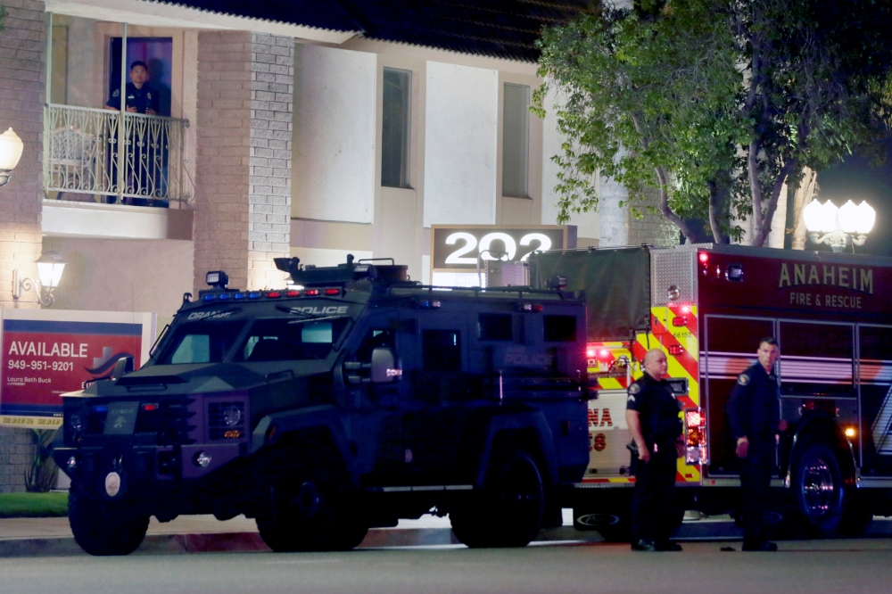 City of Orange police officers stand in front of a building after a shooting in Orange, California, U.S. March 31, 2021. Reuters/Alex Gallardo