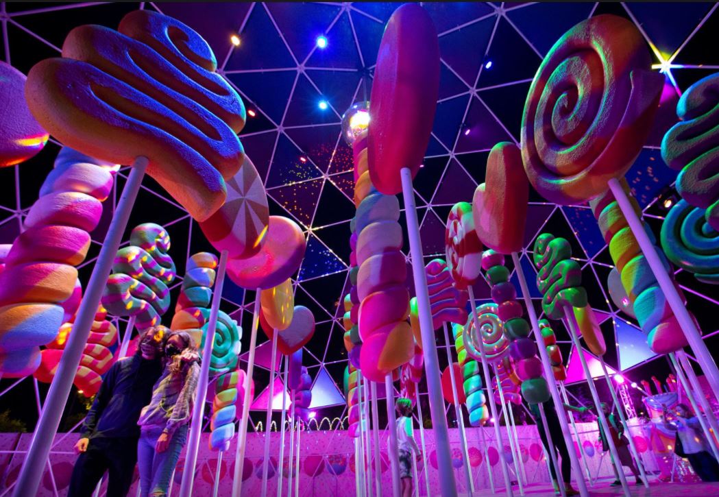 Guests pose for photos by an installation at the 