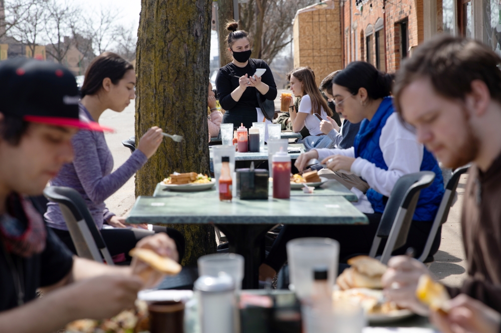 People crowd outdoor seating at a restaurant as coronavirus disease (COVID-19) restrictions are eased in Ann Arbor, Michigan, U.S., April 4, 2021. REUTERS/Emily Elconin
