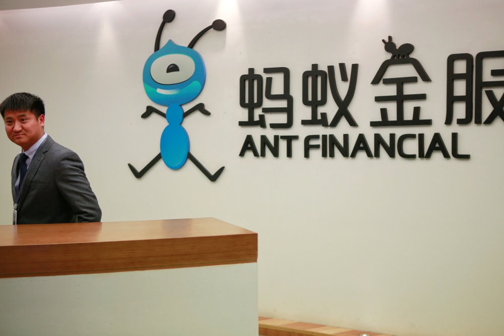 An employee stands next to the logo of Ant Financial Services Group, Alibaba's financial affiliate, at its headquarters in Hangzhou, Zhejiang province, China January 24, 2018. Reuters/Shu Zhang/File Photo