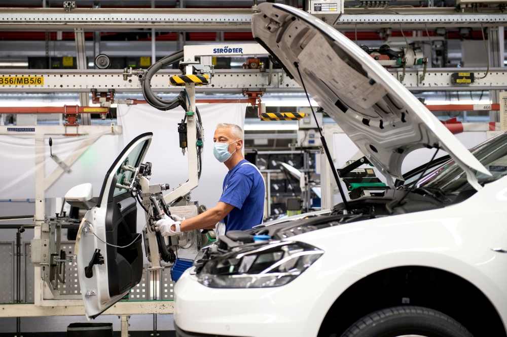 A worker wears a protective mask at the Volkswagen assembly line after VW re-starts Europe's largest car factory after coronavirus shutdown in Wolfsburg, Germany, April 27, 2020, as the spread of the coronavirus disease (COVID-19) continues. Swen Pfoertne