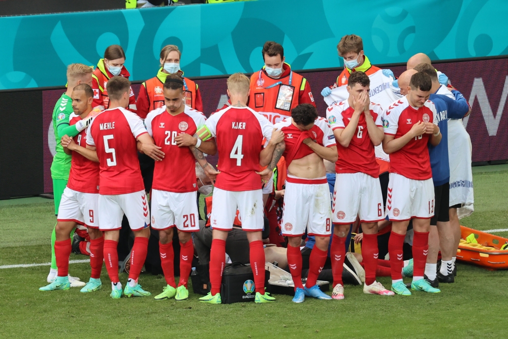 Denmark players react as Christian Eriksen receives medical attention after collapsing during the match Pool via REUTERS/Wolfgang Rattay