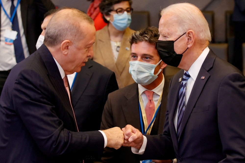 Turkey's President Tayyip Erdogan fist bumps U.S. President Joe Biden during a plenary session at a NATO summit in Brussels, Belgium, June 14, 2021. Olivier Matthys/Pool