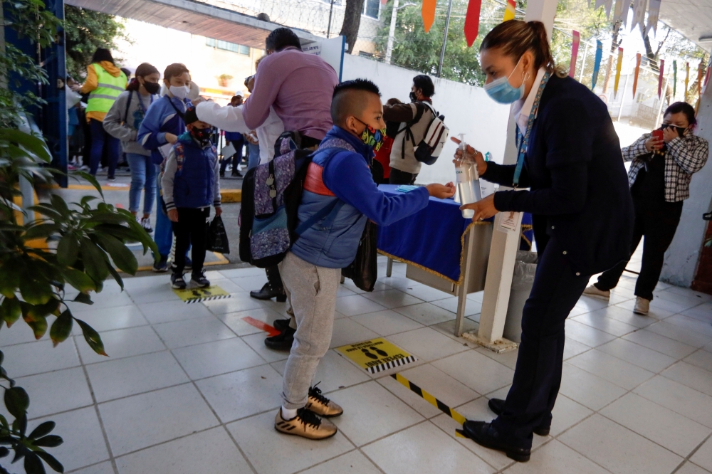 A child receives hand sanitizer while arriving at the Ignacio Zaragoza elementary school. (Reuters/Luis Cortes/File Photo)