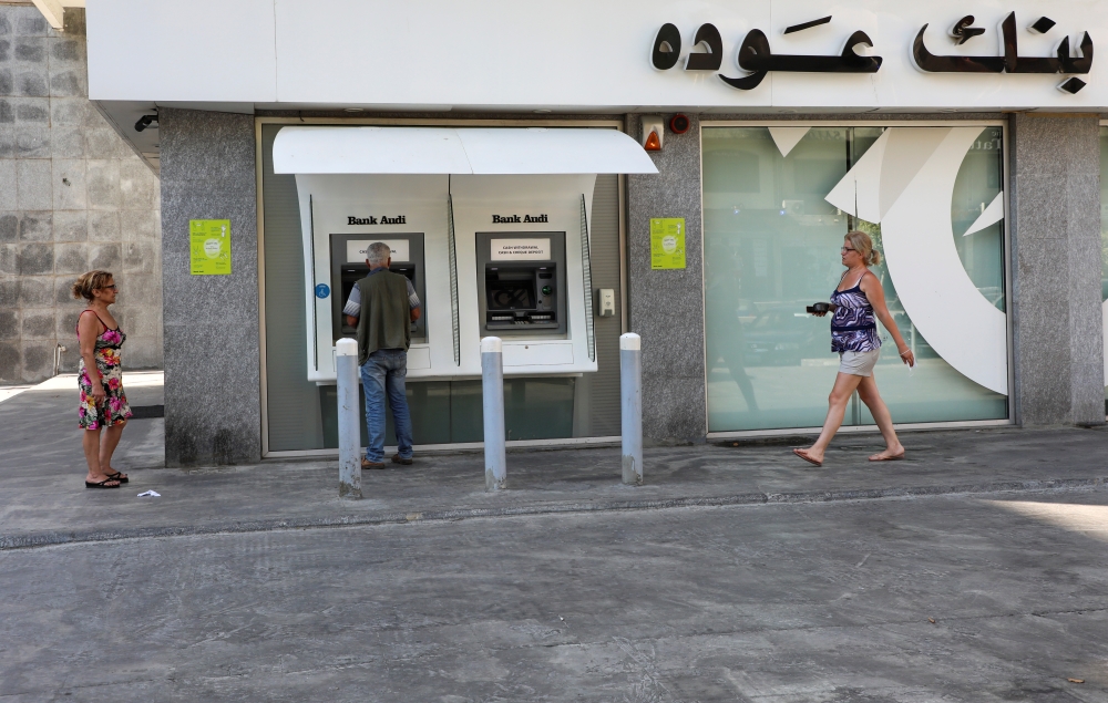 A man uses an ATM at a Bank Audi branch, after banks closed on Tuesday in solidarity with the Lebanese Swiss Bank, in Beirut, Lebanon June 29, 2021. REUTERS/Mohamed Azakir
