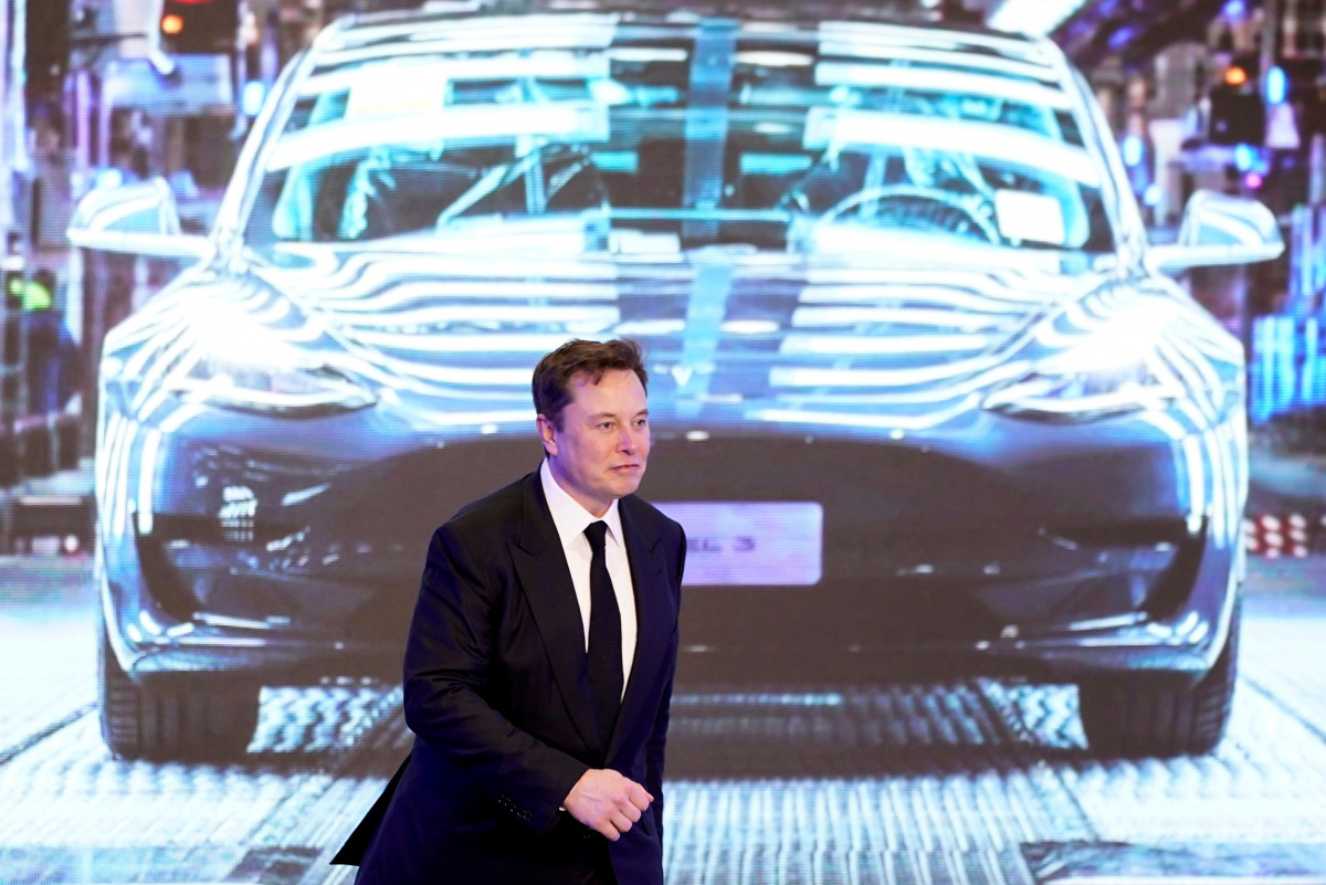 FILE PHOTO: Tesla Inc CEO Elon Musk walks next to a screen showing an image of Tesla Model 3 car during an opening ceremony for Tesla China-made Model Y program in Shanghai, China January 7, 2020. REUTERS/Aly Song/File Photo

