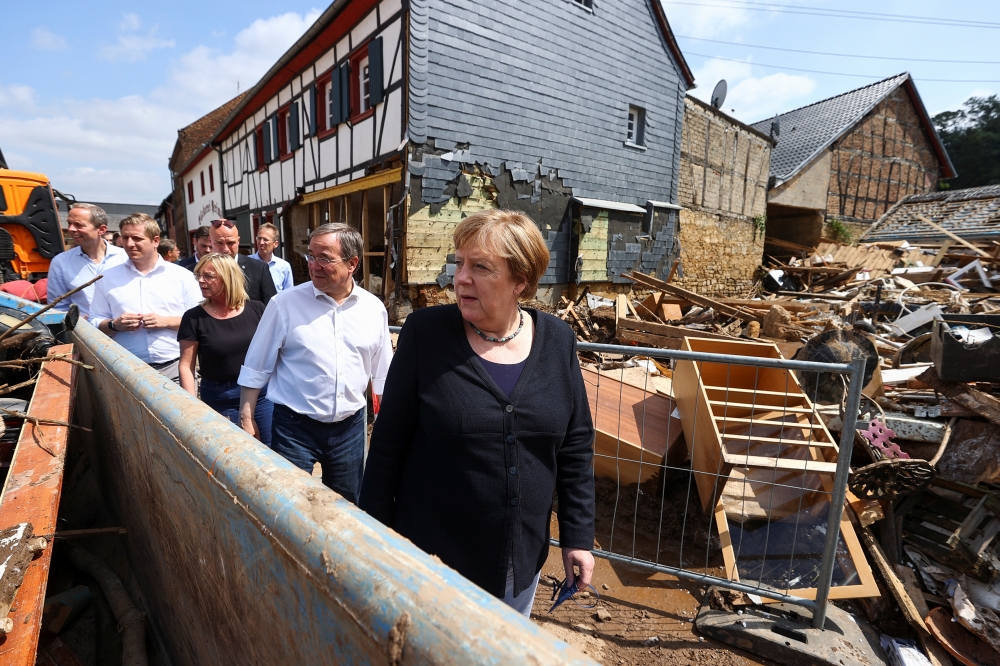 German Chancellor Angela Merkel and North-Rhine Westphalian State Premier Armin Laschet visit the area affected by floods caused by heavy rainfalls, in Iversheim, a suburb of Bad Muenstereifel, North-Rhine Westphalian state, Germany July 20, 2021. REUTERS