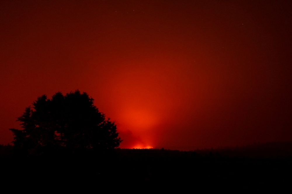 The Bootleg Fire glows in the distance, near Beatty, Oregon, U.S., July 13, 2021. Picture taken July 13, 2021. REUTERS/Mathieu Lewis-Rolland/File Photo