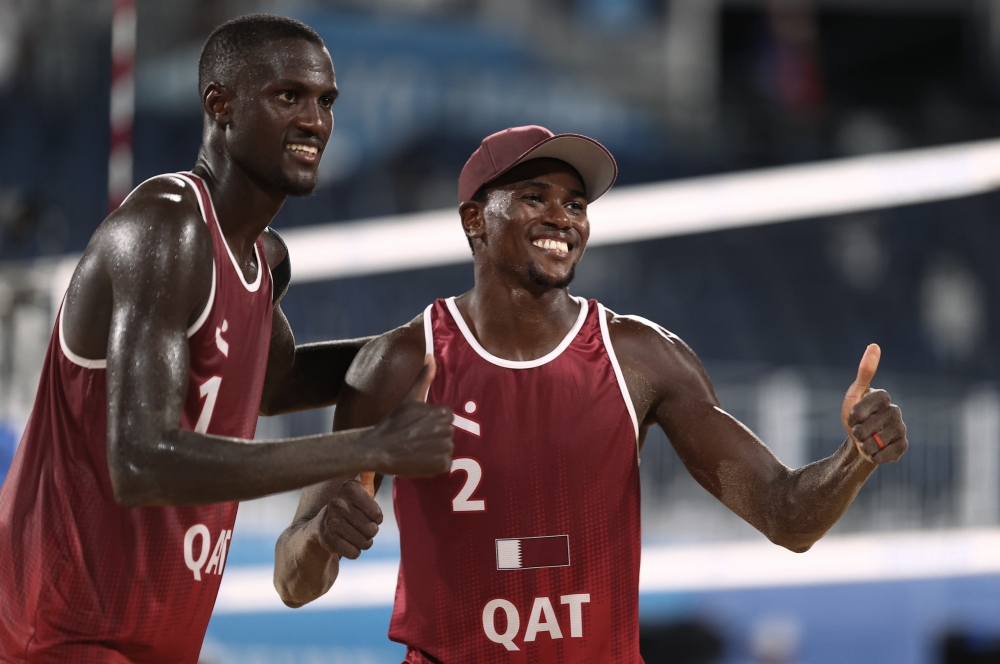 Cherif Younousse of Qatar and Ahmed Tijan of Qatar pose for a picture as they celebrate winning their match against Italy. REUTERS/Pilar Olivares