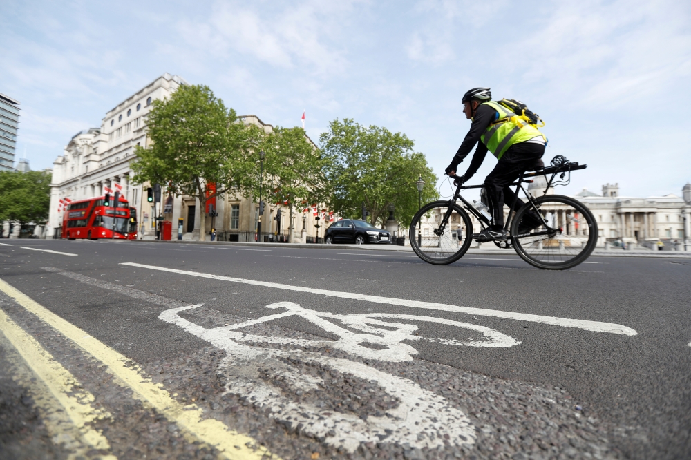 A man cycles by a cycle lane in Trafalgar Square, following the outbreak of the coronavirus disease (COVID-19), London, Britain, May 16, 2020. REUTERS/Peter Nicholls/File Photo