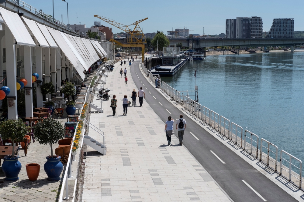 People walk by the bank of Sava river in Belgrade, Serbia, May 13, 2020. Picture taken May 13, 2020. REUTERS/Marko Djurica/File Photo