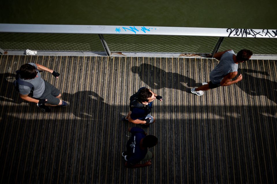 People jog on the Passerelle Simone de Beauvoir, amid the coronavirus disease (COVID-19) outbreak in Paris, France, August 1, 2021. REUTERS/Sarah Meyssonnier

