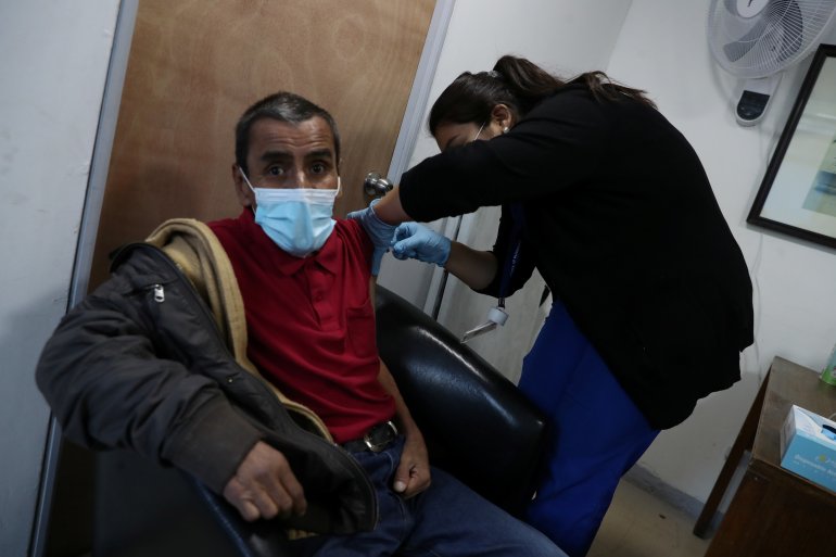 A homeless man receives a dose of Sinovac's CoronaVac coronavirus disease (COVID-19) vaccine during a vaccination campaign for homeless people, in Santiago, Chile March 26, 2021. REUTERS/Ivan Alvarado

