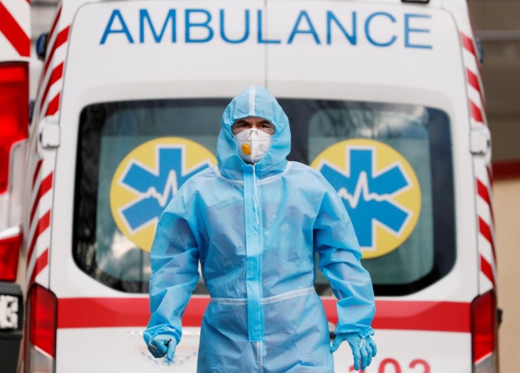 A medical worker wearing protective gear stands next to an ambulance outside a hospital for patients infected with the coronavirus disease (COVID-19) in Kyiv, Ukraine November 24, 2020. REUTERS/Gleb Garanich/File Photo/File Photo