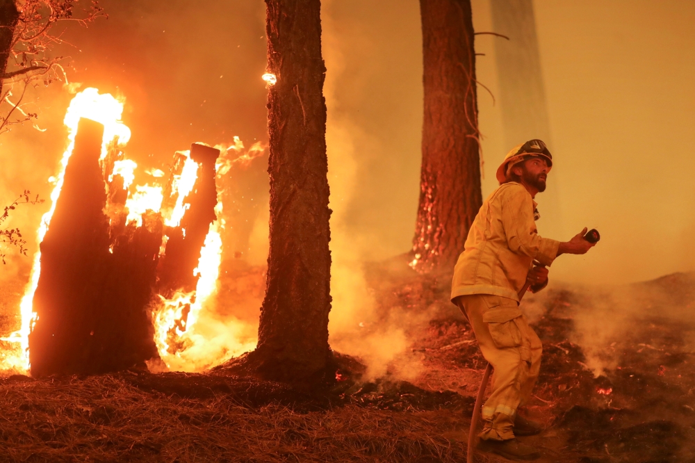 A firefighter continues to hold the line of the Dixie Fire near Taylorsville, California, U.S., August 10, 2021. REUTERS/David Swanson