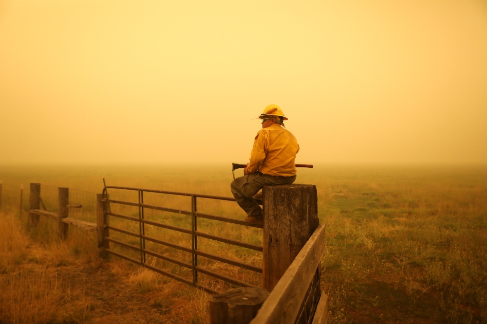 Juan Valencia, a crewman from Porterville, California keeps an eye out for spot fires from the Dixie Fire near Taylorsville, California, U.S., August 11, 2021. REUTERS/David Swanson