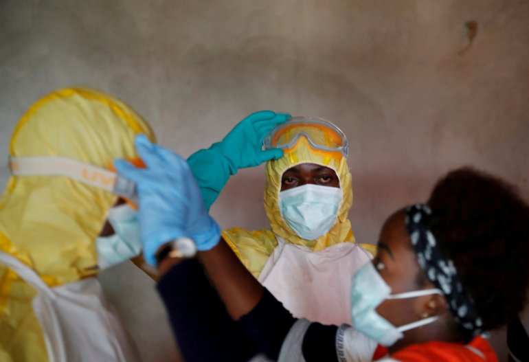 FILE PHOTO: Healthcare workers adjust gear during a funeral of a person who is suspected of dying of Ebola in Beni, North Kivu Province of Democratic Republic of Congo, December 9, 2018. REUTERS/Goran Tomasevic/File Photo
