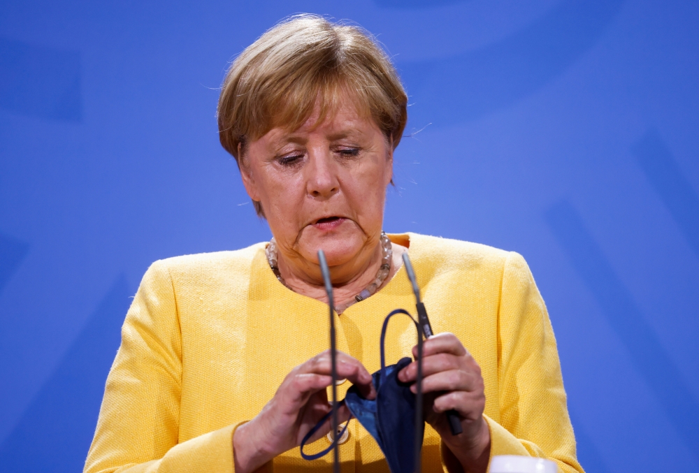German Chancellor Angela Merkel holds a protective mask during a news conference on the current developments in Afghanistan, at the Chancellery in Berlin, Germany August 16, 2021 Odd Andersen/REUTERS