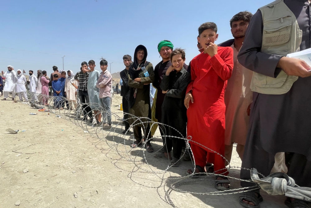 People wait outside Hamid Karzai International Airport in Kabul, Afghanistan August 17, 2021. REUTERS/Stringer